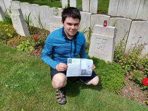 Student Gymnázia Turnov Josef Otmar u hrobu padlého vojína Československé samostatné obrněné brigády Jindřicha Langera na vojenském hřbitově v St. Omer, Francie, červen 2024